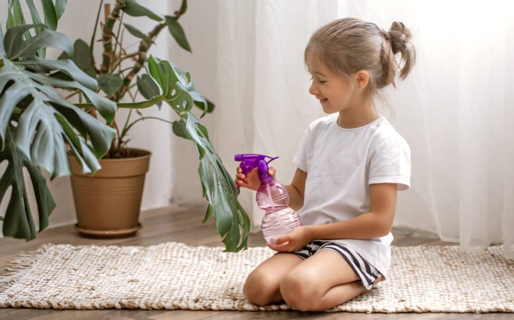 Niña pulverizando una planta