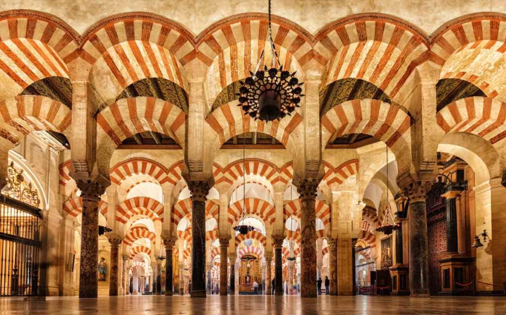 Interior de la Mezquita-Catedral de Córdoba en España. Arcos, columnas y lámparas.