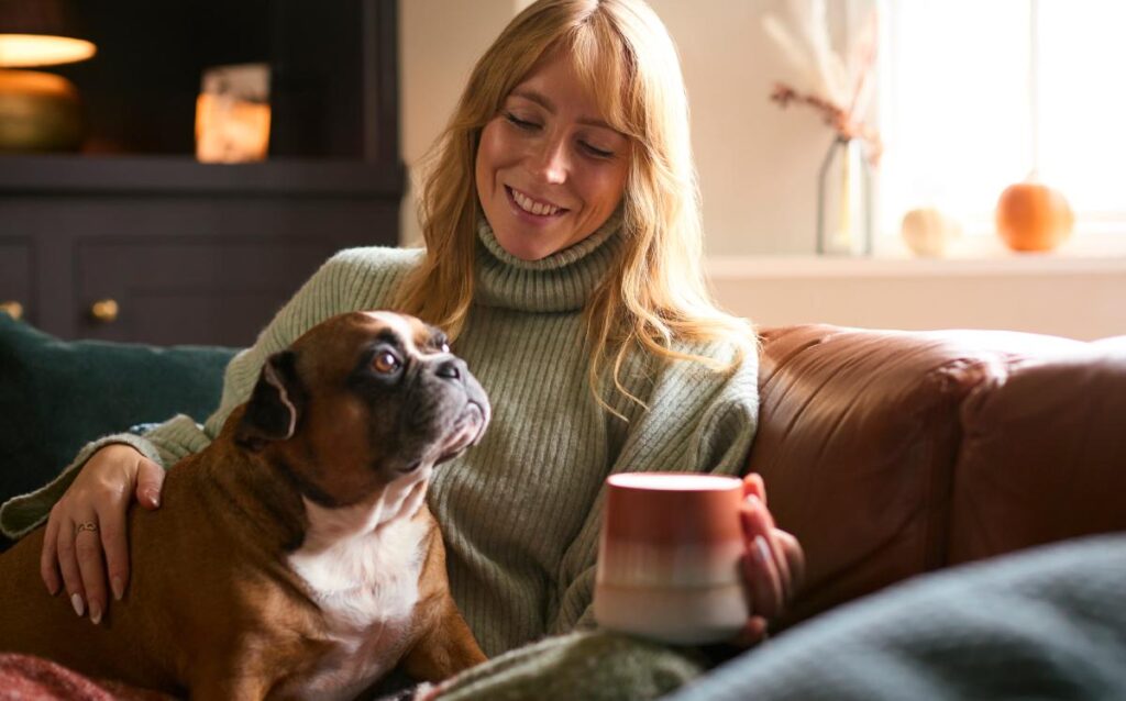 Mujer con perro en el sofá de casa