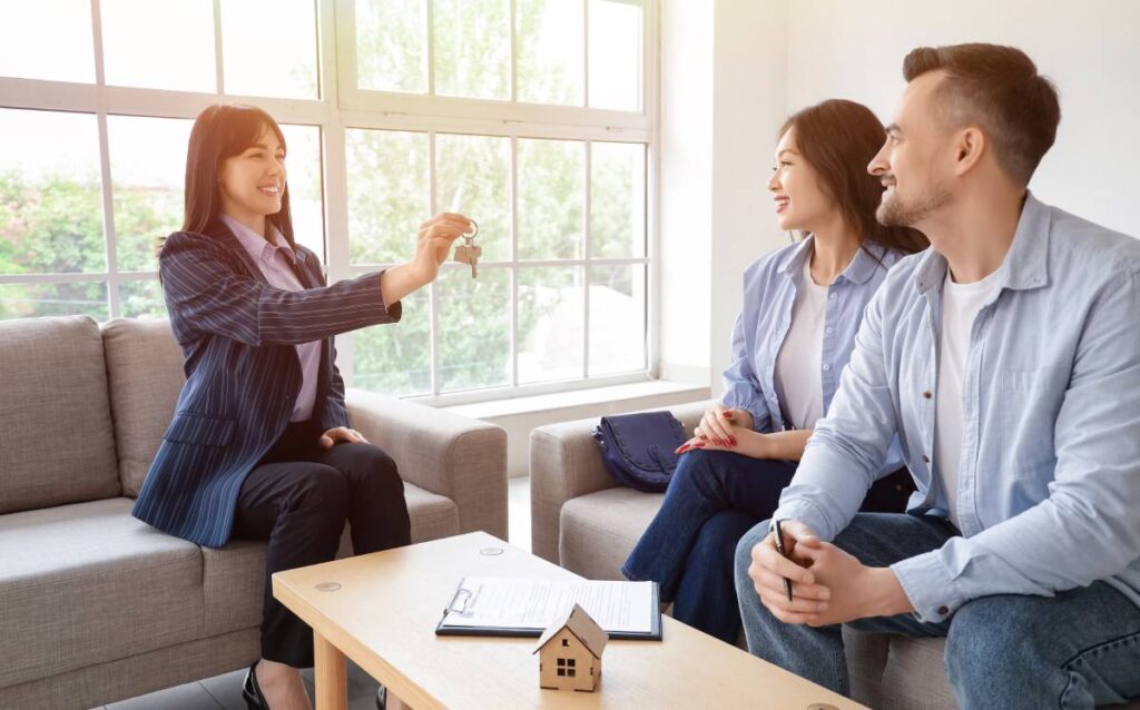 mujer entragando llaves a pareja