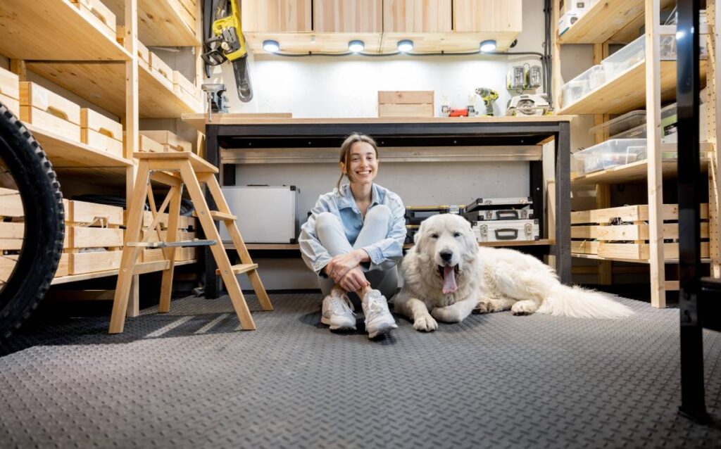 Mujer sentada con un perro en el garaje