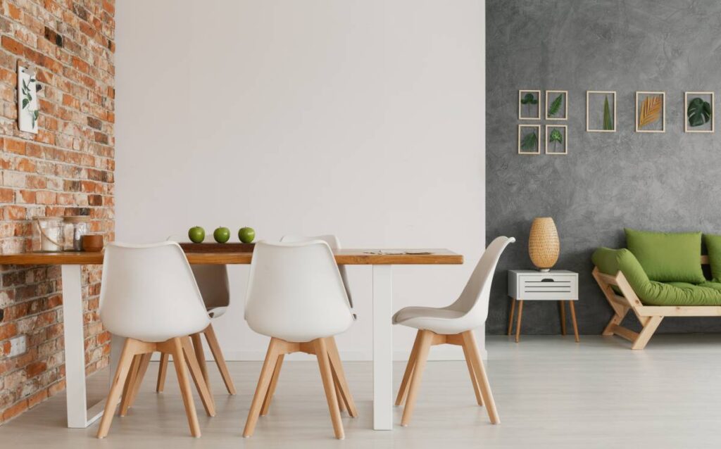 Mesa con sillas en un salón con pared de ladrillo visto