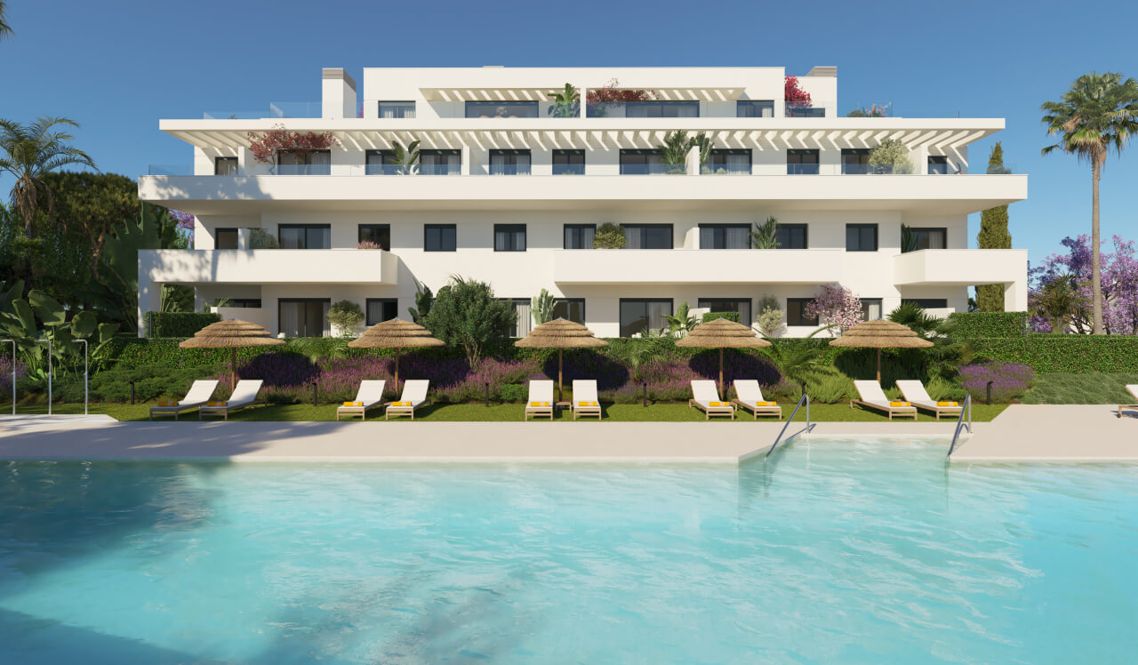 Edificio de Célere Nayra frente a la piscina con tumbonas y sombrillas