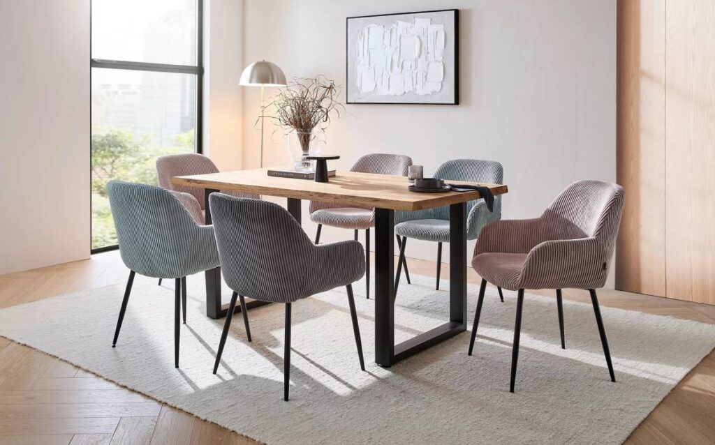 Comedor moderno con mesa de madera maciza y sillas tapizadas en tonos pastel con patas metálicas