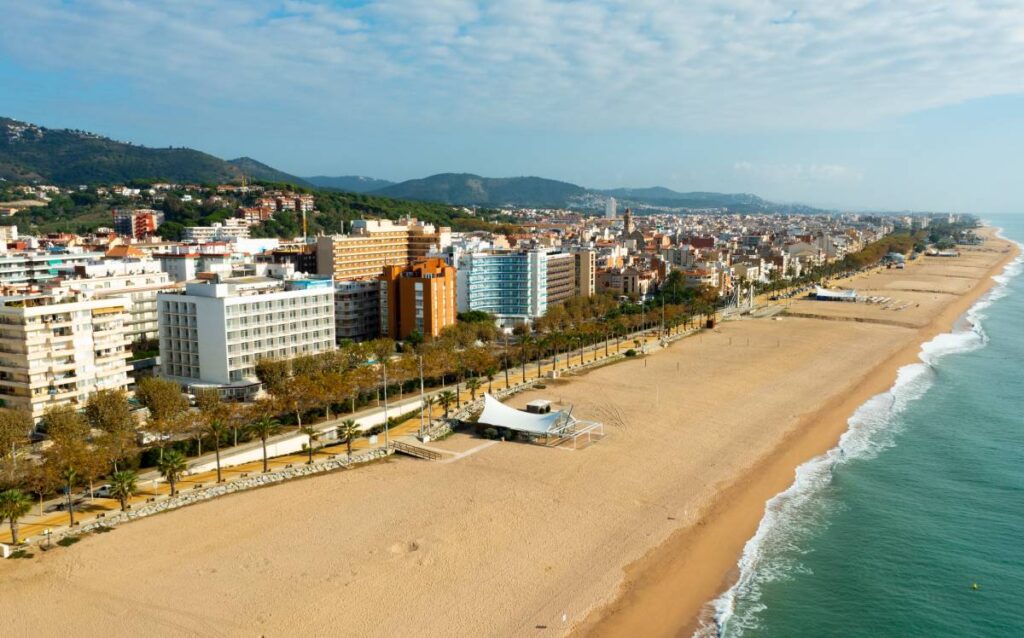 Vista aérea de una extensa playa de arena dorada en la comarca del Maresme