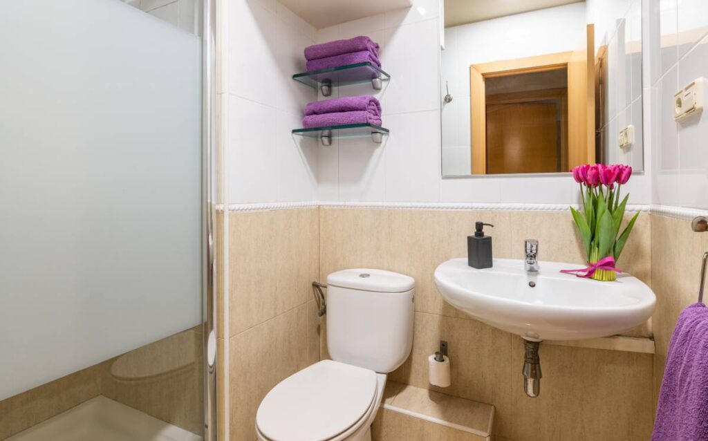 Baño pequeño con azulejos beige y blancos