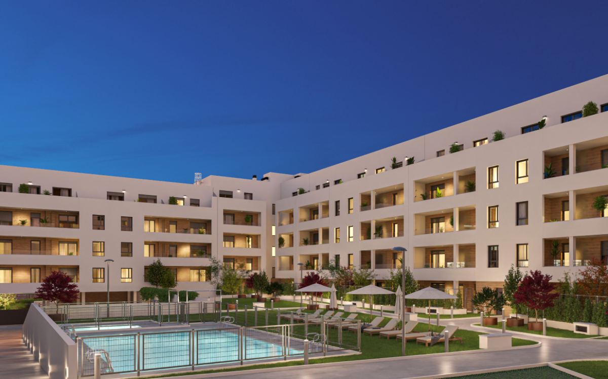 Zonas comunes con piscina y jardín en edificio residencial de noche