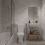 Baño de diseño contemporáneo en la promoción de obra nueva Vía Célere Jara, con bañera, mampara de cristal, lavabo suspendido, espejo decorativo y acabados en tonos neutros.