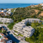 Vista aérea de Vía Célere Victoria I, promoción de obra nueva situada junto al mar, con viviendas de diseño contemporáneo, amplias terrazas, zonas ajardinadas, piscina y un entorno natural privilegiado.