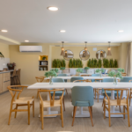 Espacio gourmet de Célere Arce con cocina equipada, zona de comedor, área lounge y amplios ventanales.