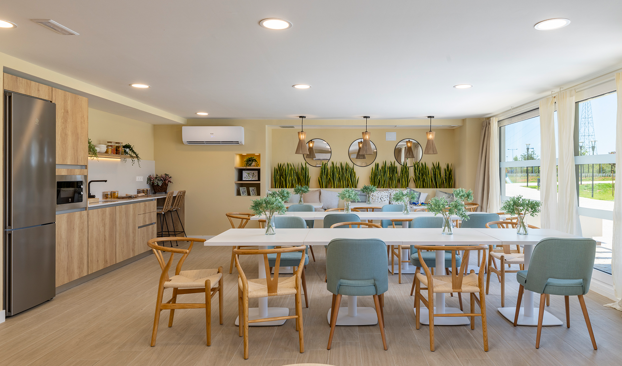 Espacio gourmet de Célere Arce con cocina equipada, zona de comedor, área lounge y amplios ventanales.