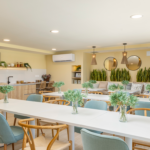Sala gourmet de Célere Arce con cocina equipada, zona de comedor, área de descanso y espacios comunes modernos diseñados para reuniones y celebraciones.