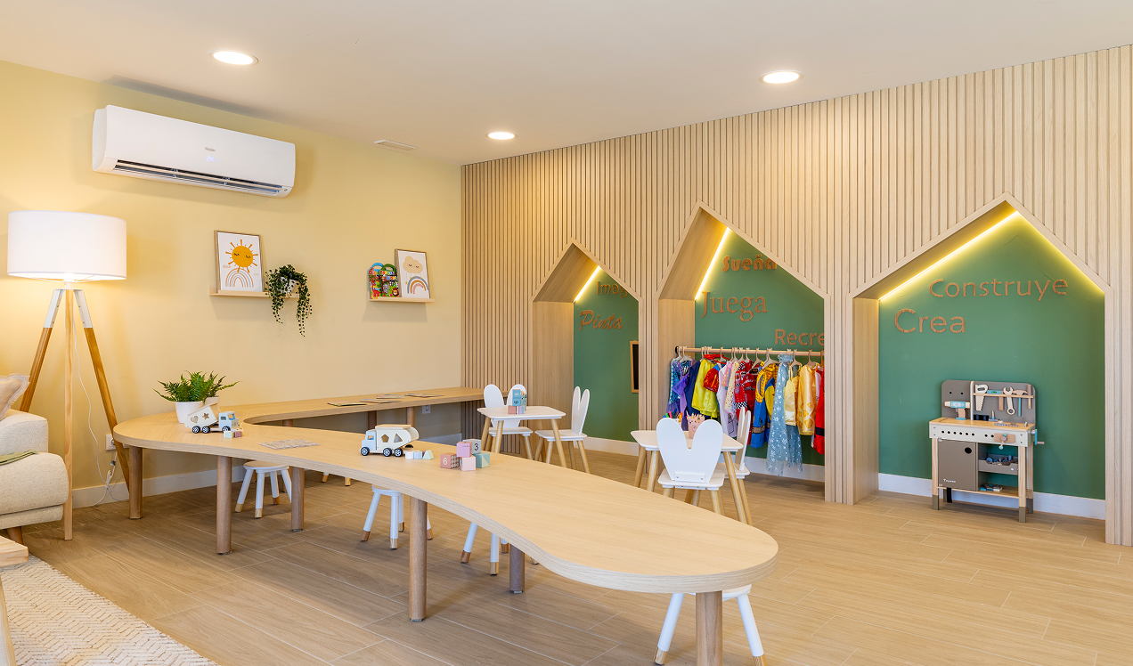 Sala infantil de Célere Arce con mesas para actividades, zona de disfraces, juguetes educativos y espacios diseñados para el entretenimiento de los más pequeños.