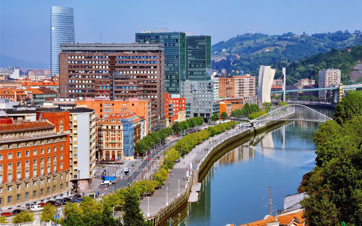 Vista aérea de la ría de Bilbao con el puente Zubizuri y edificios modernos de fondo