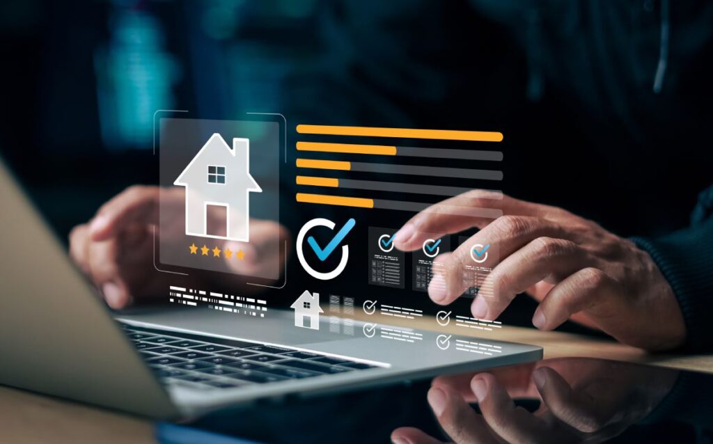 Manos utilizando un ordenador portátil con gráficos digitales de valoración inmobiliaria superpuestos