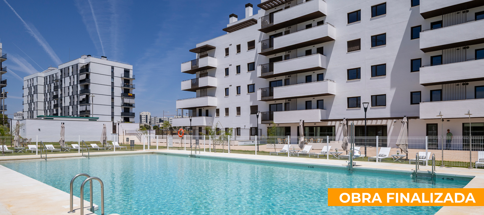 Piscina comunitaria de Célere Arce en una promoción de obra finalizada, con solárium, zonas ajardinadas y edificios residenciales modernos con amplias terrazas.