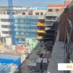 La imagen muestra el avance de las obras de una promoción de Vía Célere en julio de 2026, con varios edificios en construcción, andamios en las fachadas, una grúa torre y materiales de obra distribuidos por el recinto.