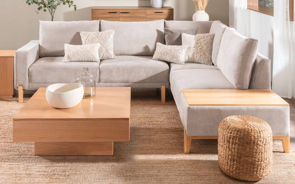 Salón moderno con sofá beige, alfombra de fibras naturales, mesa de madera y puf de mimbre