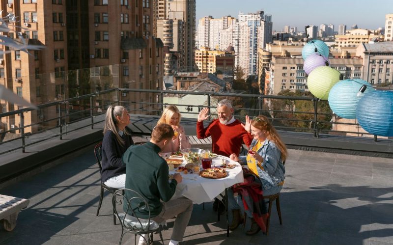 Familia celebrando una comida en una terraza comunitaria de uso privativo